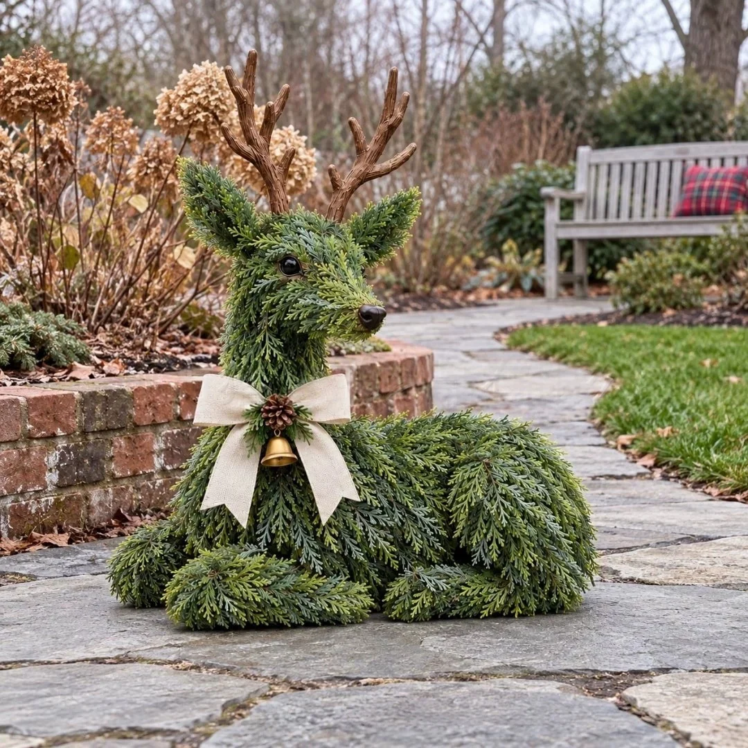Green reindeer Christmas decoration displayed on a garden stone pathway