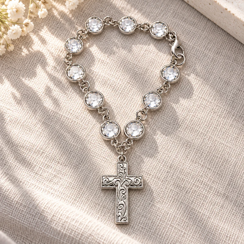 One complete silver-tone cross charm with clear faceted beads and an ornate metal pendant