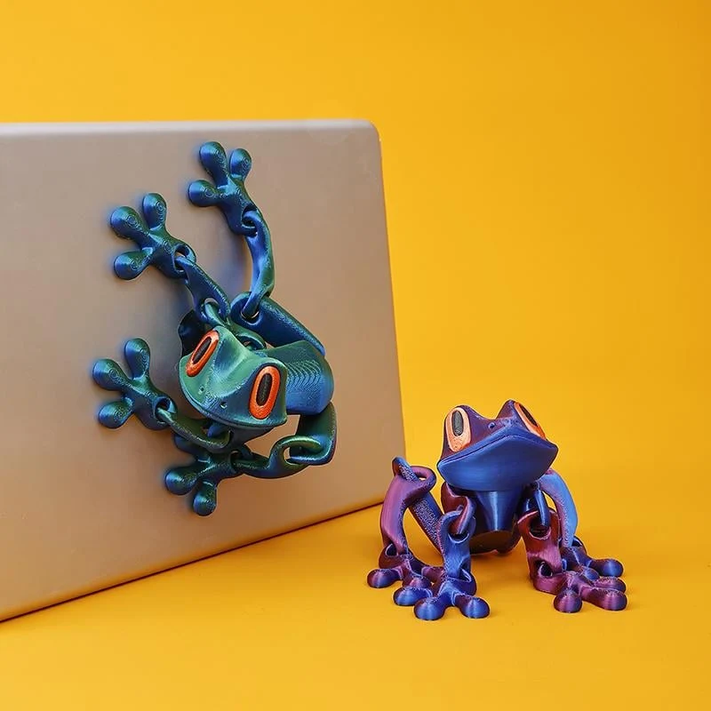 Two colorful articulated magnetic frogs climbing a metal surface