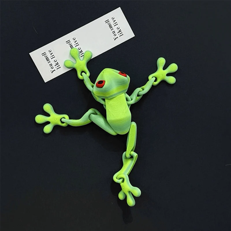 3D printed green magnetic frog attached to a metal surface