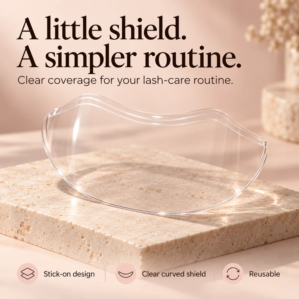 Transparent curved lash shower shield on a beige vanity surface showing its clear shape