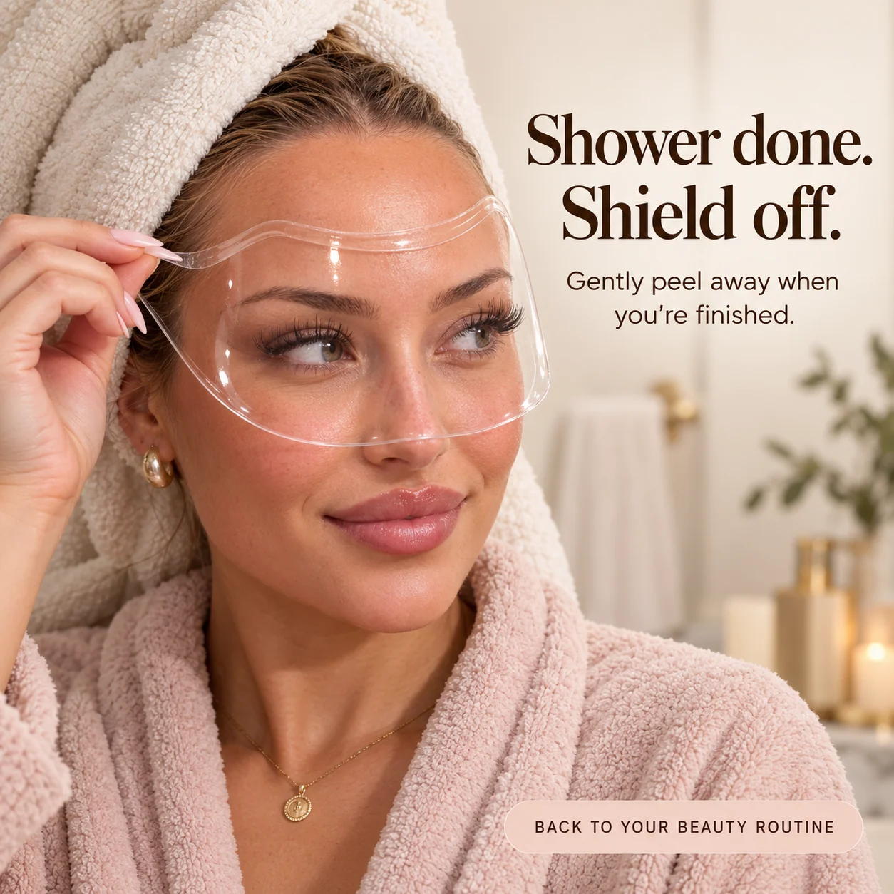 Woman in a bathrobe and towel gently lifting the lash shield away after washing