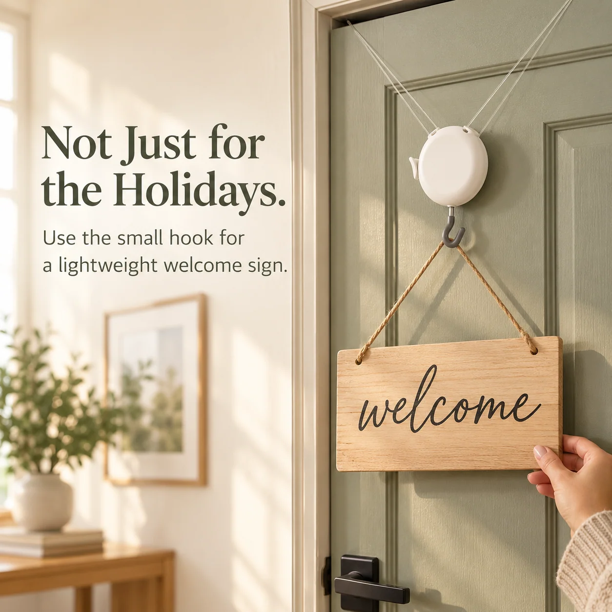 Adjustable round white hanger holding a lightweight wooden welcome sign against a sage-green door