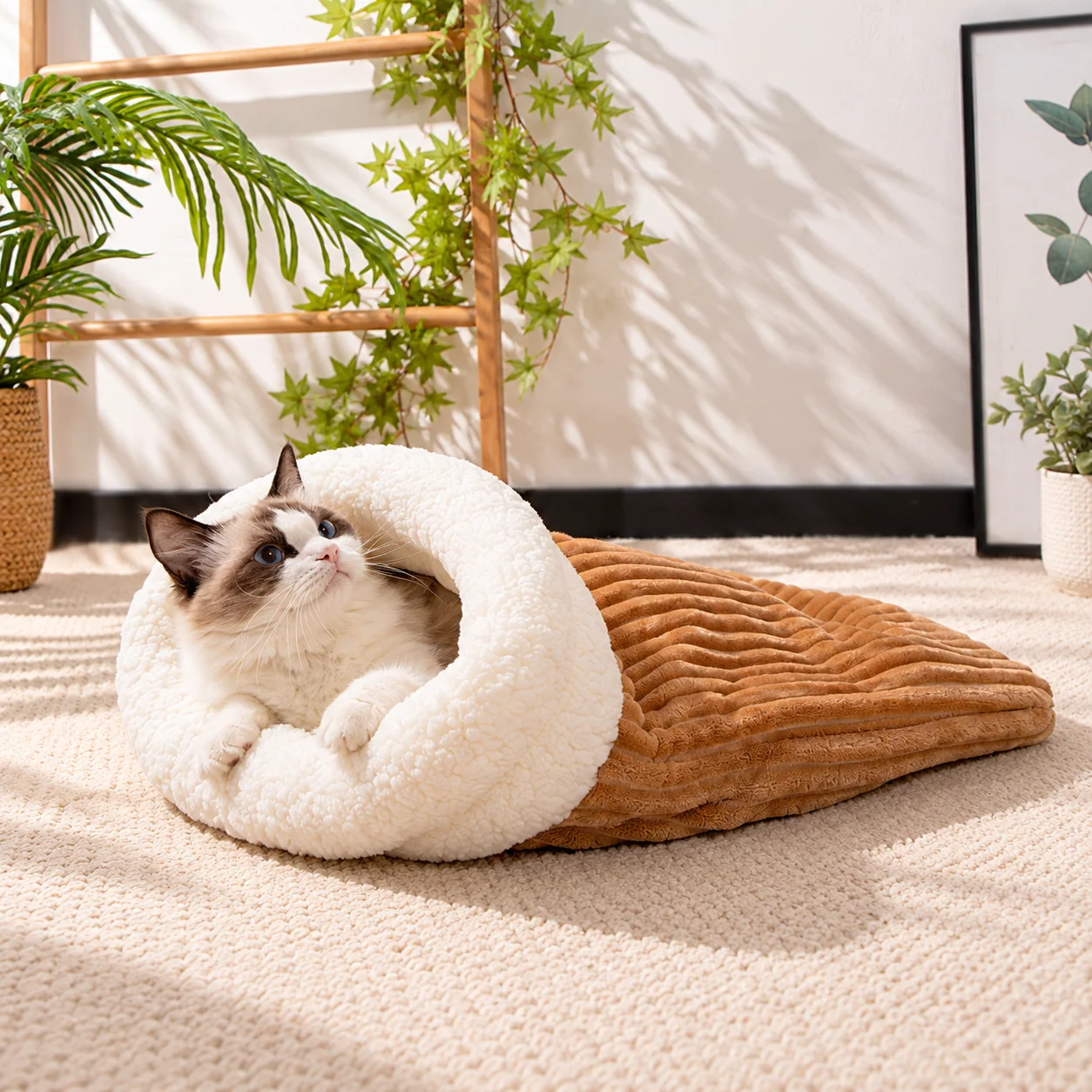 Cat relaxing in cozy covered sleeping bag nest
